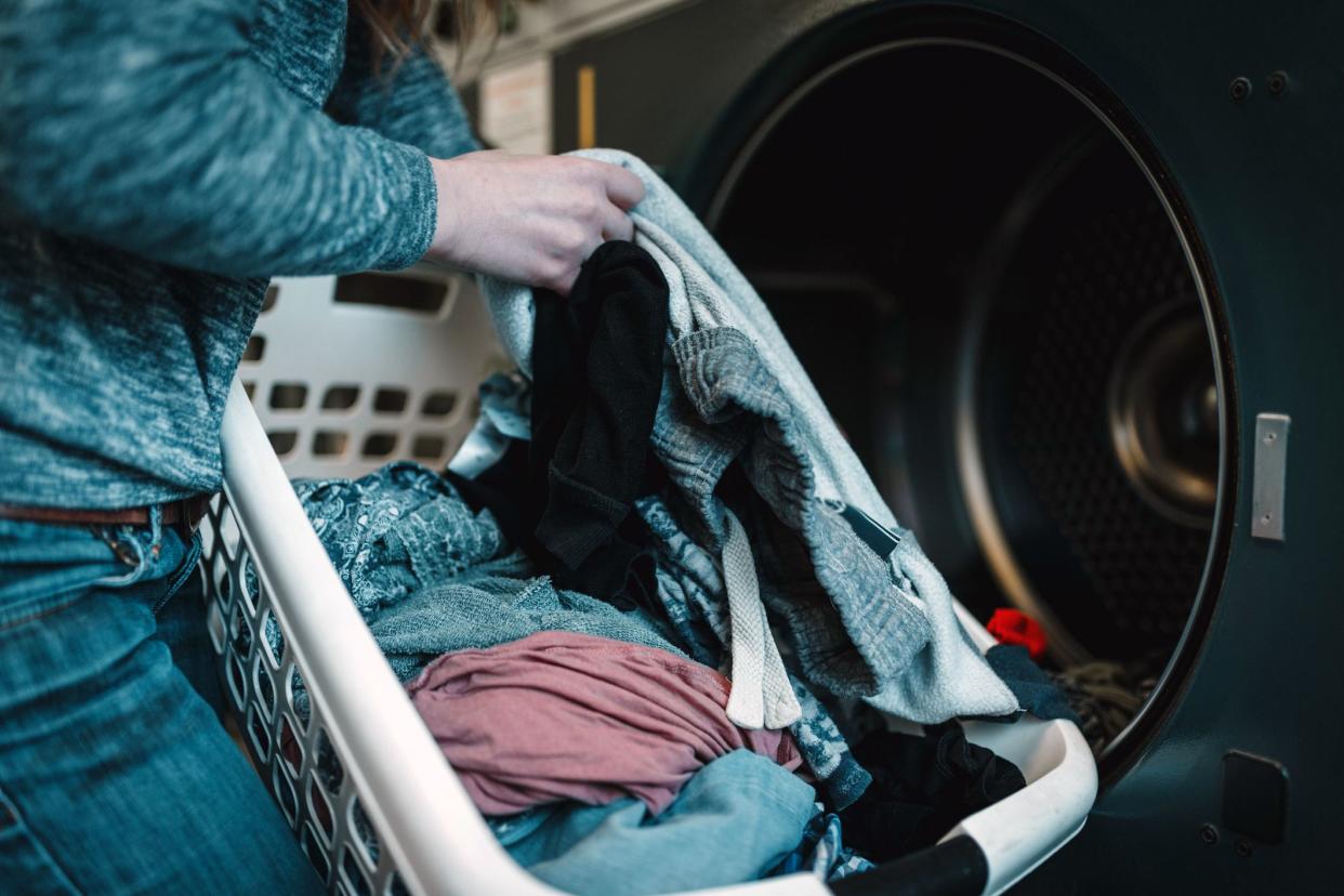 woman pulling clean clothes out of washer