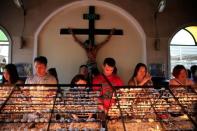 Filipino Catholic devotees light candles and offer prayers after attending a mass at a National Shrine of Our Mother of Perpetual Help in Baclaran, Paranaque city, metro Manila, Philippines September 18, 2016. REUTERS/Romeo Ranoco/File Photo