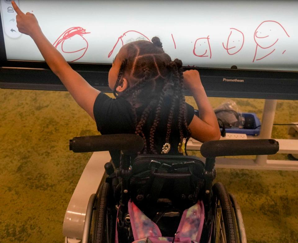 Kay’Mia Franks draws on the smart board inside of the new Gaenslen Library which is fully accessible to students with disabilities and special needs.