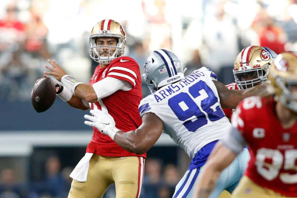 49ers quarterback Jimmy Garoppolo throws the ball as Cowboys defensive end Dorance Armstrong closes in.