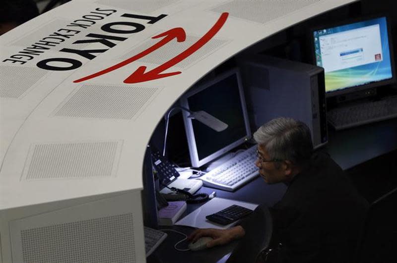 An employee of the Tokyo Stock Exchange (TSE) looks at a monitor at the bourse at the TSE in Tokyo March 3, 2014. REUTERS/Issei Kato