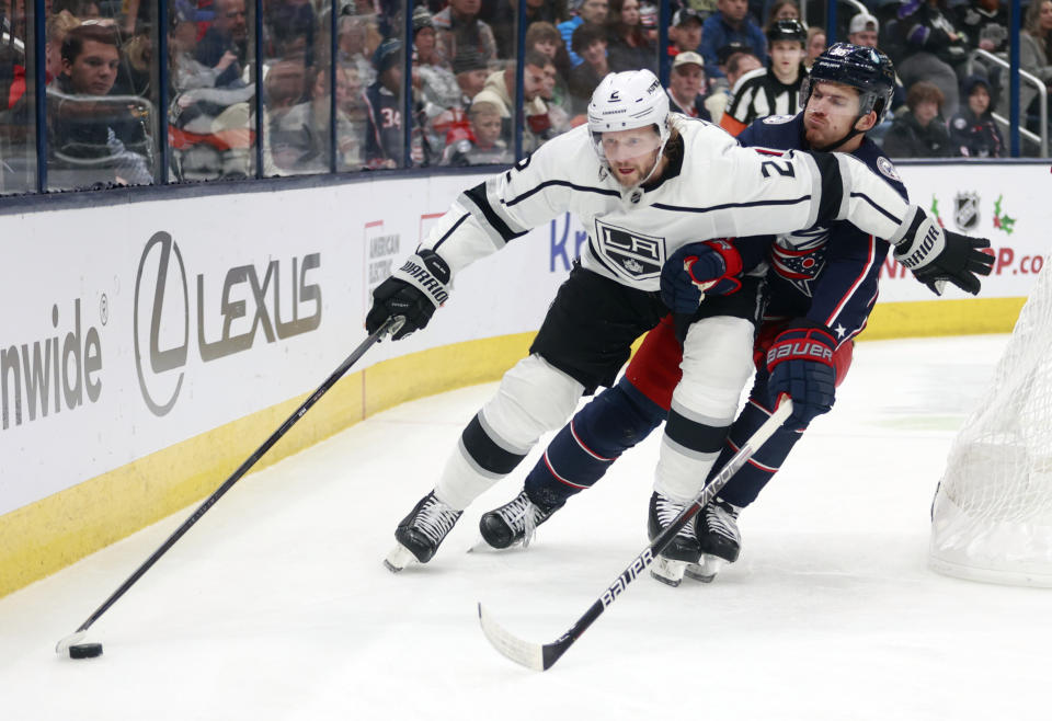 Los Angeles Kings defenseman Alexander Edler, left, controls the puck in front of Columbus Blue Jackets forward Jack Roslovic during the second period of an NHL hockey game in Columbus, Ohio, Sunday, Dec. 11, 2022. (AP Photo/Paul Vernon)