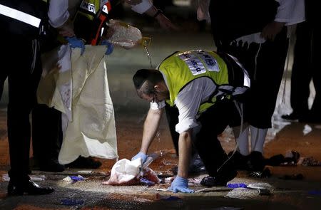 A member of the Zaka Rescue and Recovery team cleans blood stains at the scene where a Palestinian was shot dead after he stabbed and killed two people in Jerusalem's Old City October 3, 2015. REUTERS/Ammar Awad