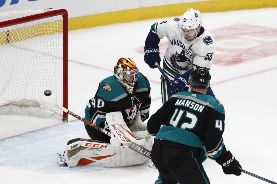 Anaheim Ducks goaltender Kevin Boyle, left, deflects the puck as teammate Josh Manson and Vancouver Canucks' Bo Horvat watch during the third period of an NHL hockey game Wednesday, Feb. 13, 2019, in Anaheim, Calif. The Ducks won 1-0. (AP Photo/Jae C. Hong)