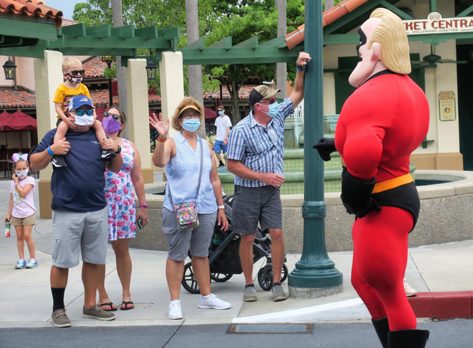 Guests wave to Mr. Incredible during a pop-up appearance of Pixar characters at Disney's Hollywood Studios at Walt Disney World on July 16, the second day of the park's reopening, in Lake Buena Vista, Florida. (Photo: Orlando Sentinel via Getty Images)