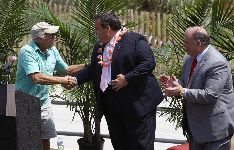 Singer Jimmy Buffett, left, greets New Jersey Gov. Chris Christie, second right, and Sen. Stephen M. Sweeney, right, D-West Deptford, on the Boardwalk in Atlantic City, N.J., Monday, July, 24, 2012, as Buffett announced that he is teaming up with Resorts Casino Hotel to bring one of his Margarativille casino-entertainment complexes to Atlantic City. The project will be built as an addition to the Resorts Casino Hotel. (AP Photo/Mel Evans)