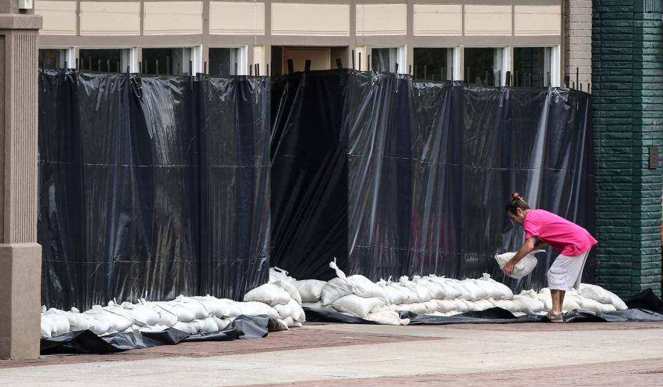 Kevin Johnson of Georgetown helps place sandbags in front of the Caldwell Banker building on Front Street in downtown Georgetown, South Carolina, on Sept. 4, 2019.