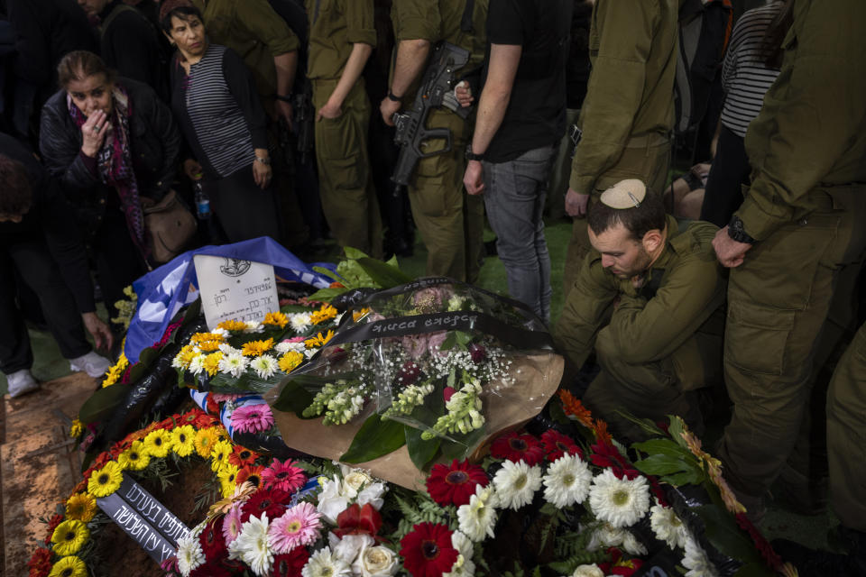 Family and friends of Israeli reservist Yair Cohen gather around his grave during his funeral at Kiryat Shaul military cemetery in Tel Aviv, Israel, Tuesday, Feb. 13, 2024. Cohen, 30, was killed during Israel's ground operation in the Gaza Strip, where the Israeli army has been battling Palestinian militants in the war ignited by Hamas' Oct. 7 attack into Israel. (AP Photo/Oded Balilty)