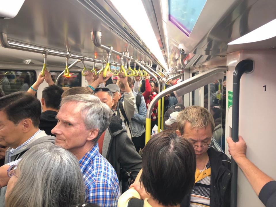 Metro Trains Sydney commuters appear to be squished together in a packed carriage.
