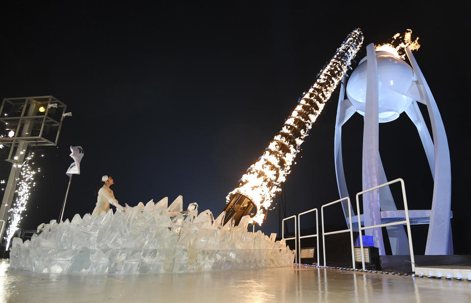 Yuna Kim lights the Olympic flame during Friday’s opening ceremony. (AP)