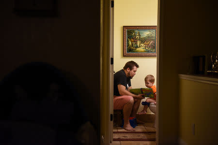 Will Hoffmann, husband of Lauren Hoffmann, reads a book to his two-year old son Asa, who is being potty trained, in San Antonio, Texas, U.S., February 6, 2019. REUTERS/Callaghan O'Hare