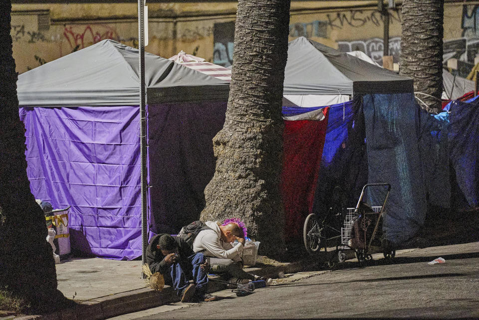 People sleep outside their tents set on the sidewalk early morning Wednesday, June 26, 2024 in the West Lake area of Los Angeles. The number of homeless residents counted in Los Angeles County has dipped slightly, decreasing by about 0.3% since last year as California continues to struggle with the long-running crisis of tens of thousands of people sleeping in cars and encampments. (AP Photo/Damian Dovarganes)