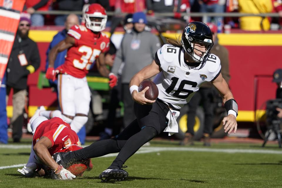 Jacksonville Jaguars quarterback Trevor Lawrence (16) runs with the ball as Kansas City Chiefs safety Bryan Cook (6) defends during the first half of an NFL football game Sunday, Nov. 13, 2022, in Kansas City, Mo. (AP Photo/Ed Zurga)