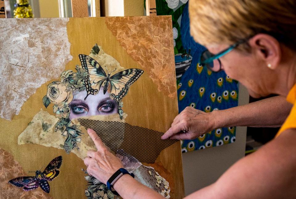 Ulrike holds up a mesh fabric while contemplating adding a mask to her mixed-media piece, ÒIf Truth Be Told,Ó at her home studio in Palm Springs, Calif., Wednesday, Sept. 21, 2022. 