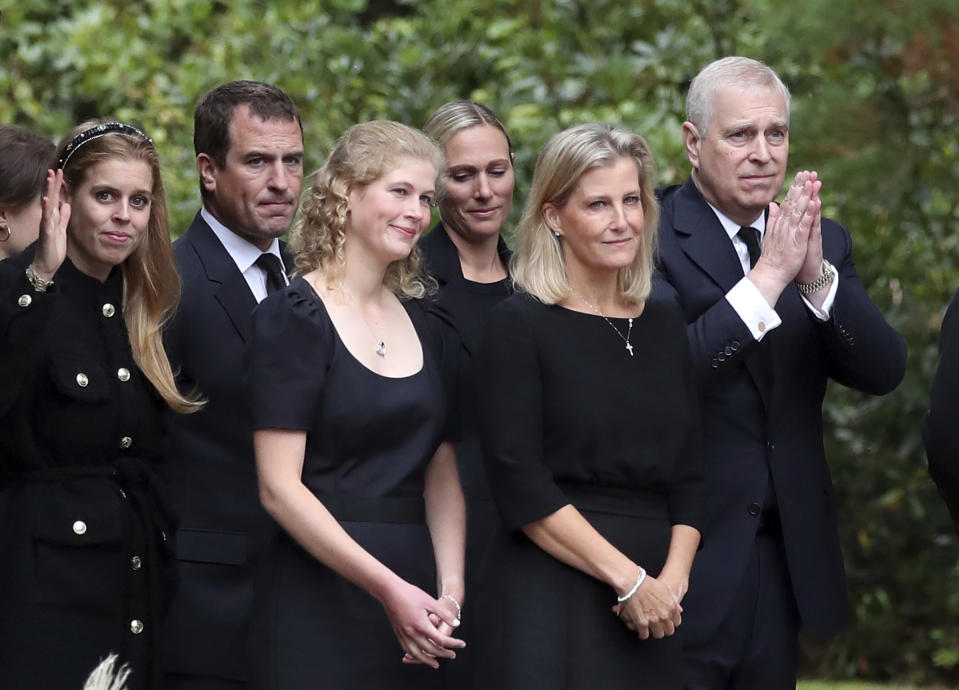 From left, Britain's Princess Beatrice, Peter Phillips, Lady Louise Windsor, Zara Tindall, Sophie Countess of Wessex and Prince Andrew,gesture to the members of the public after looking at the floral tributes for Queen Elizabeth II, as others look on, outside the gates of Balmoral Castle in Aberdeenshire, Scotland Saturday, Sept. 10, 2022. Queen Elizabeth II, Britain's longest-reigning monarch and a rock of stability across much of a turbulent century, died Thursday after 70 years on the throne. She was 96. (AP Photo/Scott Heppell)