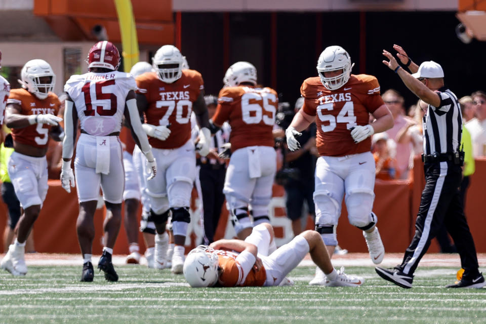 Quinn Ewers of the Texas Longhorns lays injured on the turf after a hit by Alabama's Dallas Turner in the first half on Saturday. (Tim Warner/Getty Images)