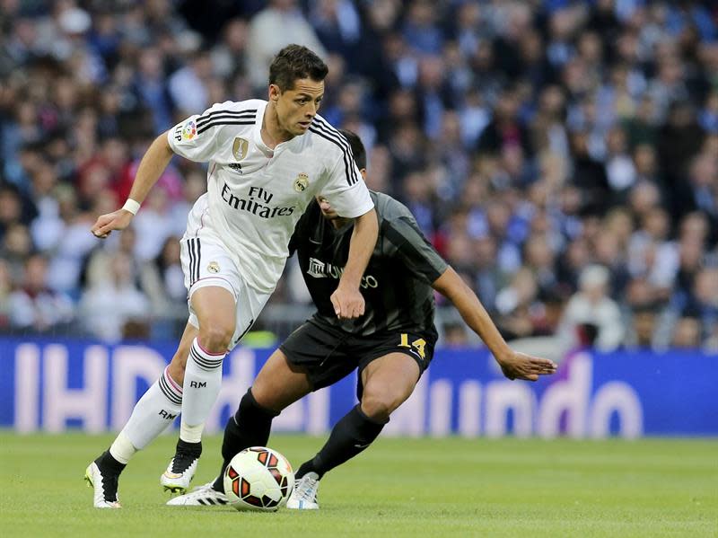 MADRID, 18/04/2015.- El delantero mexicano del Real Madrid Chicharito (i) escapa de Recio, del Málaga, durante el partido de Liga en Primera División disputado esta tarde en el estadio Santiago Bernabéu, en Madrid. EFE/Ballesteros