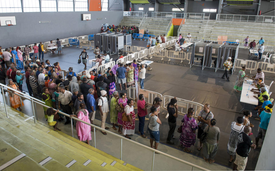 Residents of New Caledonia's capital, Noumea, wait in line at a polling station dedicated to the natives of the Loyalty islands, before casting their vote as part of an independence referendum, Sunday, Nov. 4, 2018. Voters in New Caledonia are deciding whether the French territory in the South Pacific should break free from the European country that claimed it in the mid-19th century. (AP Photo/Mathurin Derel)