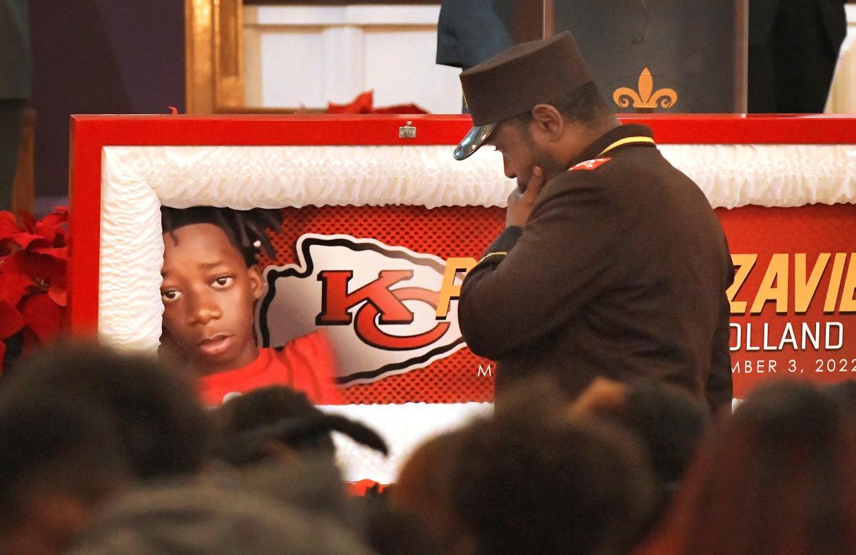 Derrick Muhammad pauses at the open coffin of his young cousin, Prince Holland, at the start of the 13-year-old's funeral Saturday.  Family and friends gathered at Zion Hope Missionary Baptist Church on Edgewood Avenue West to celebrate his life and mourn his death in a Dec. 3 drive-by shooting that wounded two other people including an 11-year-old boy.