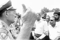 <p>A Mississippi Highway Patrolman gestures with his thumb as he orders the Rev. Dr. Martin Luther King, right, and other marchers from the pavement of U.S. 51 near Hernando on June 7, 1966. (AP Photo) </p>