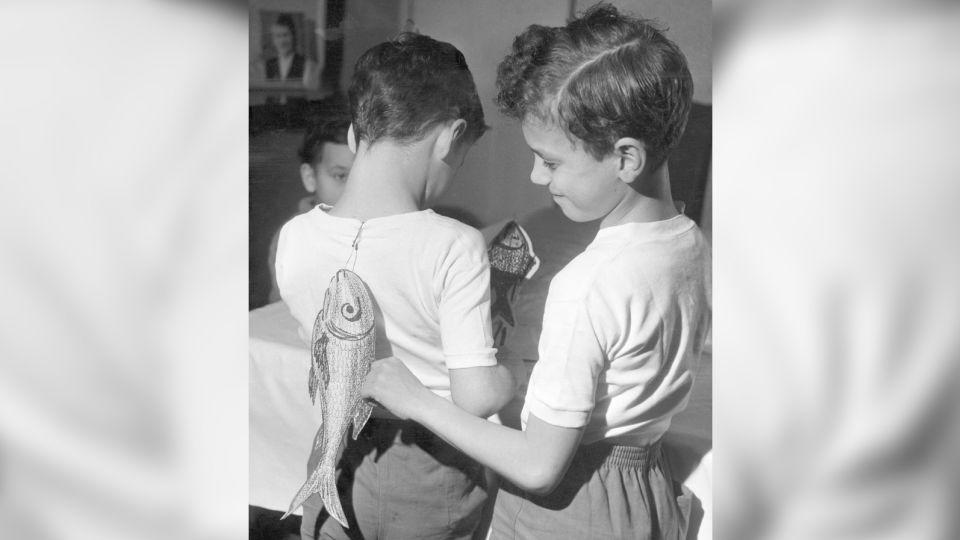 Two brothers sticking April Fools' Day fish on each other's backs on April 1, 1963.  - Gamma-Keystone/Getty Images