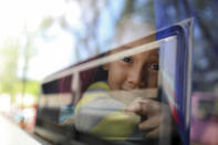 <p>A young boy peers out the window of the bus that will carry him to Mexico City from the sports club where Central American migrants traveling with the annual “Stations of the Cross” caravan had been camping out in Matias Romero, Oaxaca State, Mexico, Thursday, April 5, 2018. (Photo: Felix Marquez/AP) </p>