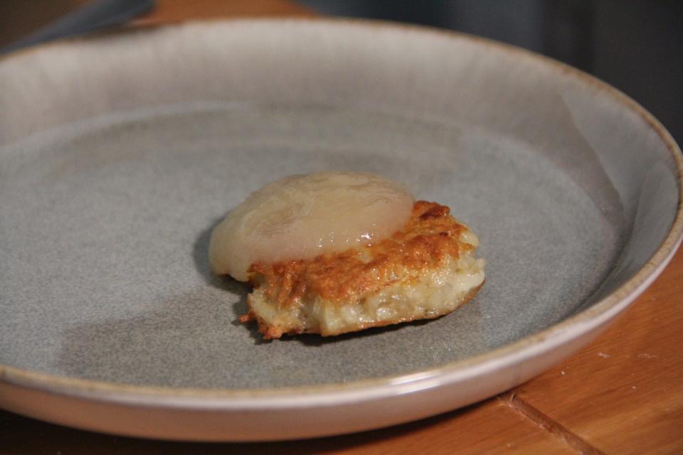 A latke made with Ina Garten's recipe topped with applesauce.