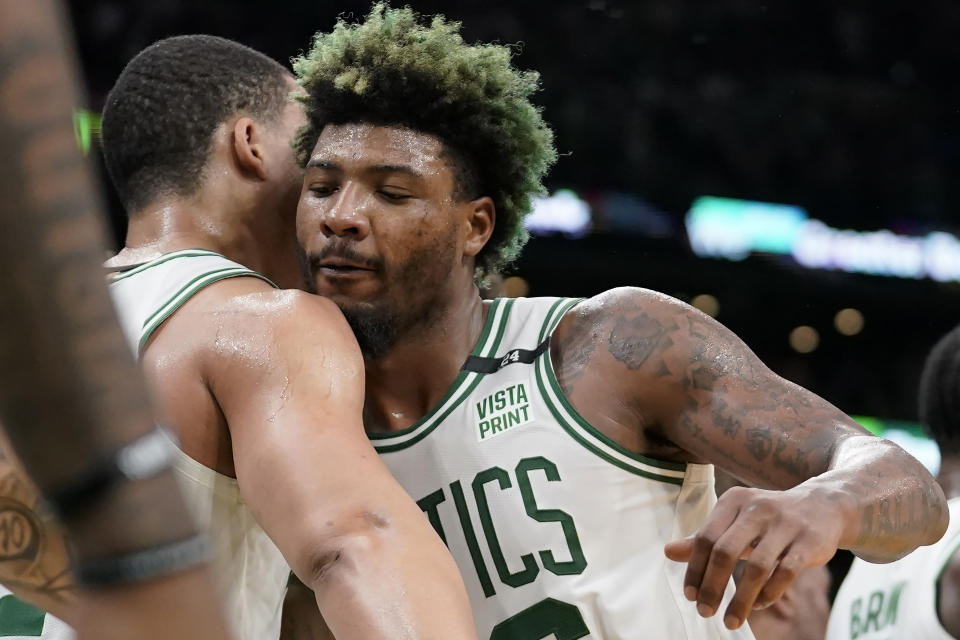 Boston Celtics guard Marcus Smart, right, celebrates with forward Grant Williams, left, as the Celtics lead the Milwaukee Bucks during the second half of Game 7 of an NBA basketball Eastern Conference semifinals playoff series, Sunday, May 15, 2022, in Boston. The Celtics won 109-81. (AP Photo/Steven Senne)