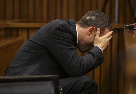 Olympic and Paralympic track star Oscar Pistorius reacts as he reaches for a bucket in the dock during his trial for the murder of his girlfriend Reeva Steenkamp, at the North Gauteng High Court in Pretoria, March 10, 2014. REUTERS/Siphiwe Sibeko
