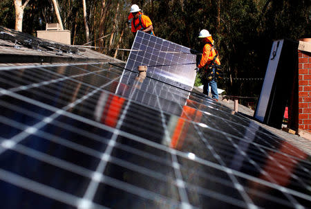 FILE PHOTO: Solar installers from Baker Electric place solar panels on the roof of a residential home in Scripps Ranch, San Diego, California, U.S. October 14, 2016. Picture taken October 14, 2016. REUTERS/Mike Blake/File Photo