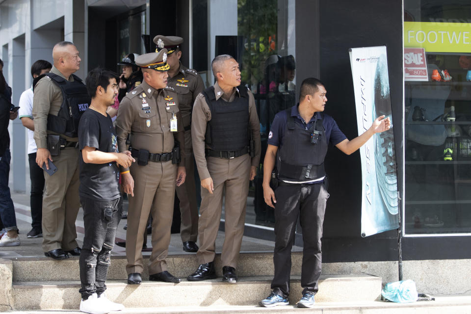 Thai police officers gather near the site of a shooting in Bangkok, Thailand, Friday, Feb. 14, 2020. Multiple gunshots have been fired into the air by a man in the middle of the capital Bangkok, police said. (AP Photo/Sakchai Lalit)