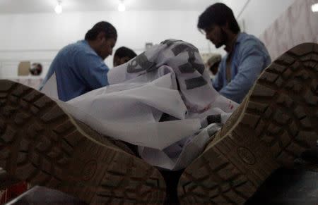 Paramedics inspect the body of one of four Frontier Corps personnel killed by gunmen in Quetta, Pakistan, June 29, 2016. REUTERS/Naseer Ahmed