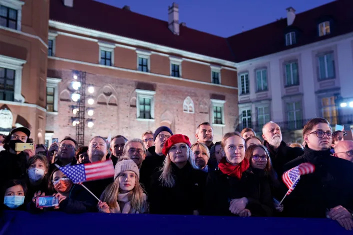 People listen as President Joe Biden delivers a speech about the Russian invasion of Ukraine, at the Royal Castle, Saturday, March 26, 2022, in Warsaw.