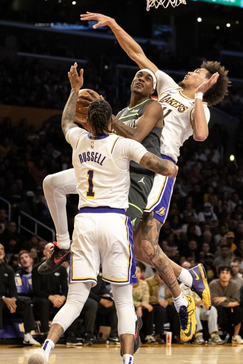 Minnesota forward Jared McDaniels drives to the basket between Lakers center Jaxson Hayes and guard D'Angelo Russell.