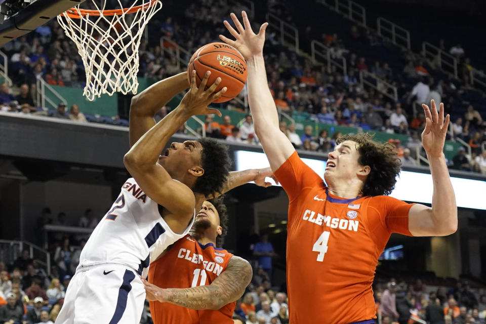 Virginia guard Reece Beekman (2) shoots against Clemson forward Ian Schieffelin (4) and guard Brevin Galloway (11) during the first half of an NCAA college basketball game at the Atlantic Coast Conference Tournament in Greensboro, N.C., Friday, March 10, 2023. (AP Photo/Chuck Burton)