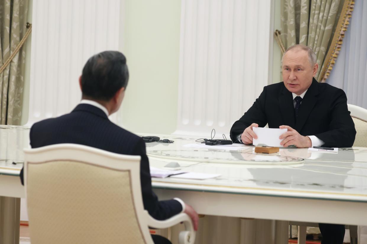 Russian President Vladimir Putin speaks to the Chinese Communist Party's foreign policy chief Wang Yi, back to a camera, during their meeting at the Kremlin in Moscow, Russia, Wednesday, Feb. 22, 2023. (Anton Novoderezhkin, Sputnik, Kremlin Pool Photo via AP)