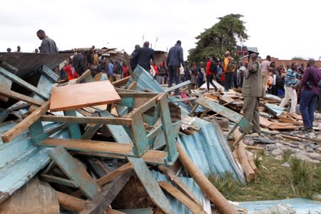 A police officer stands near the debris of a collapsed school classroom, in Nairobi