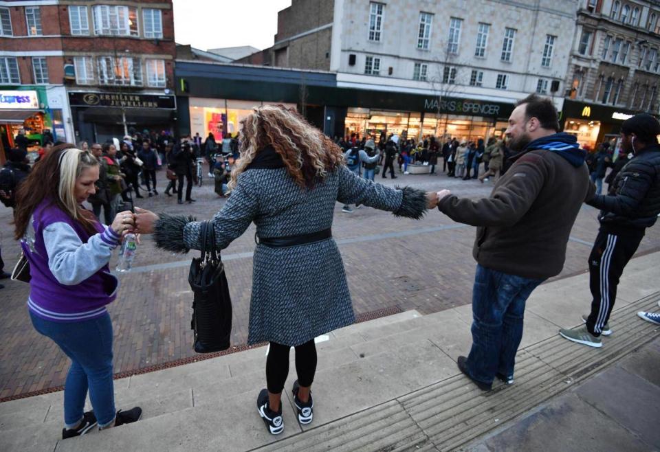 Demonstrators link hands during a protest against violent crime outside Hackney Central station (PA)