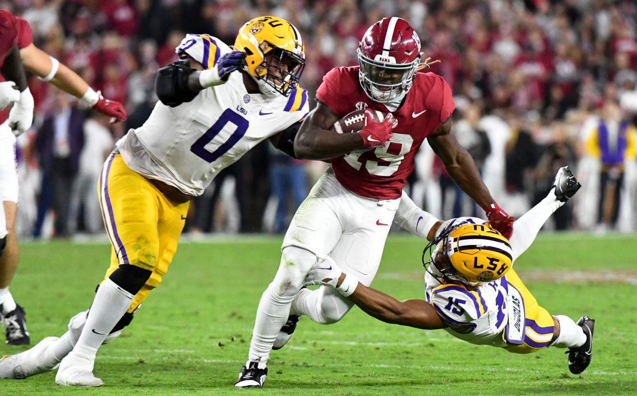 LSU Tigers defensive tackle Maason Smith pursues Alabama Crimson Tide wide receiver Kendrick Law.