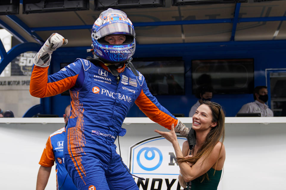 Scott Dixon, front left, of New Zealand celebrates after winning the pole during qualifications for the Indianapolis 500 auto race as his wife Emma Davies-Dixon, right, watches at Indianapolis Motor Speedway in Indianapolis, Sunday, May 23, 2021. (AP Photo/Michael Conroy)