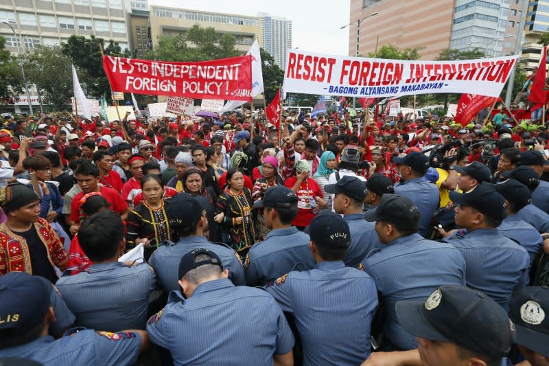 菲律賓民眾19日在馬尼拉的美國大使館附近與警方對峙，抗議標語上寫著「支持總統的外交政策」、「抵抗外國干預」。（美聯社）