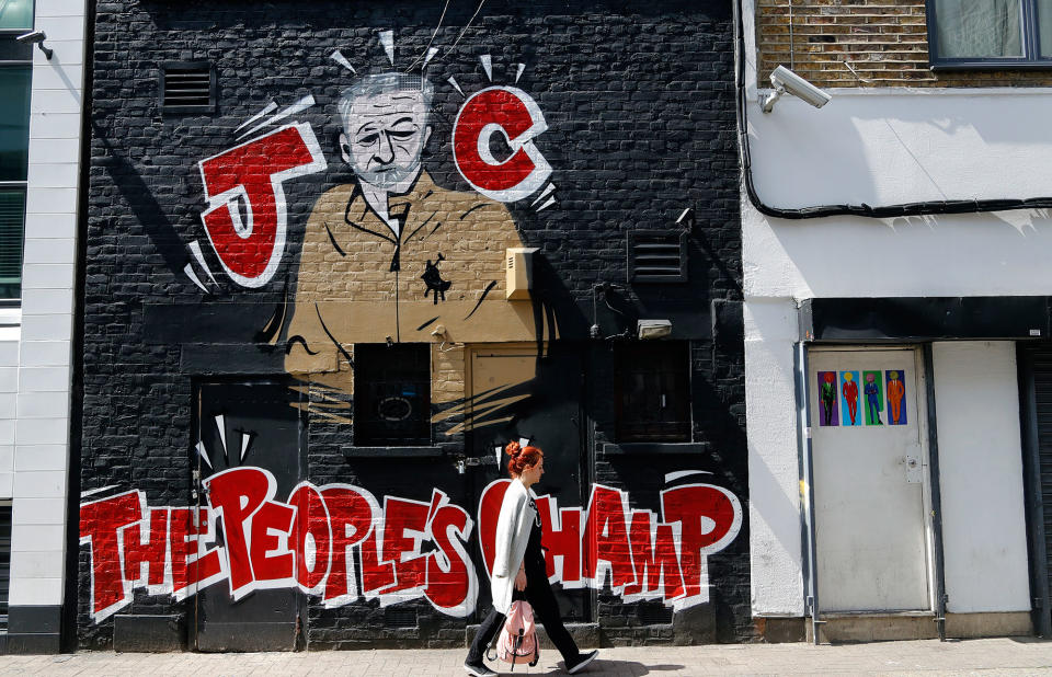 A woman walks past a Jeremy Corbyn mural