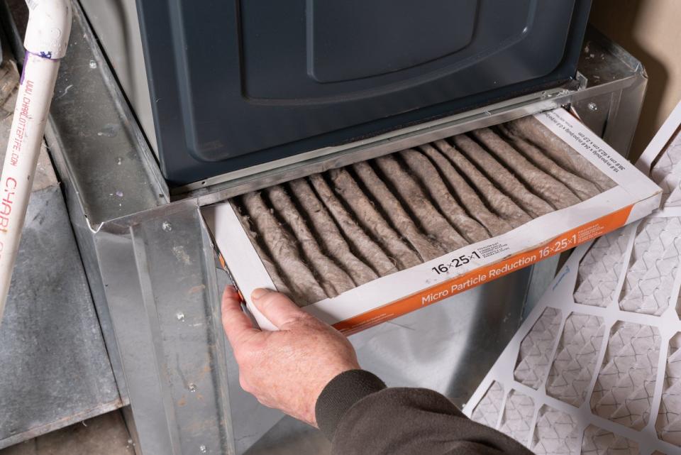 Man replacing dirty furnace filter in the home 