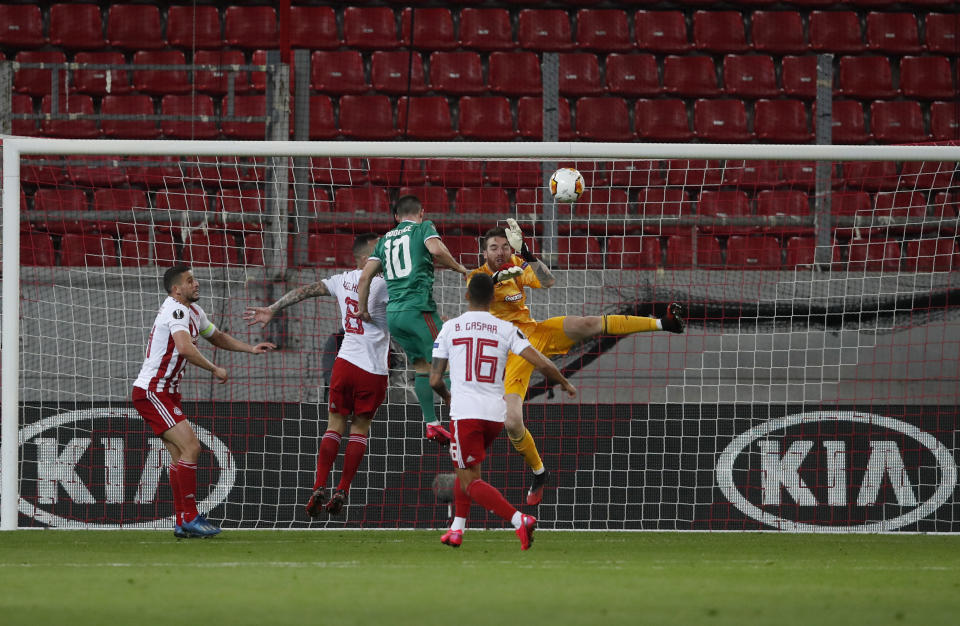 Olympiakos' goalkeeper Jose Sa, right, makes a save in front of Wolverhampton Wanderers' Daniel Podence, center, during the Europa League round of 16 first leg soccer match between Olympiakos and Wolverhampton Wanderers at the Karaiskakis Stadium in Piraeus, Greece, Thursday, March 12, 2020. The match is being played in an empty stadium because of the coronavirus outbreak. (AP Photo/Thanassis Stavrakis)
