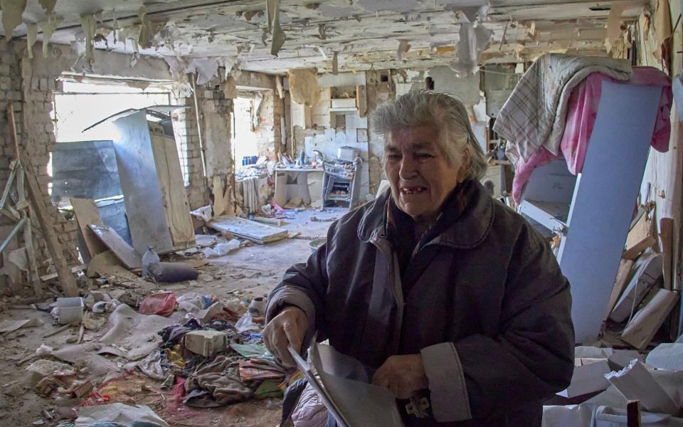 An elderly woman in the damaged flat of her son who was injured during shelling in the outskirts of Kharkiv - SERGEY KOZLOV/EPA-EFE/Shutterstock 