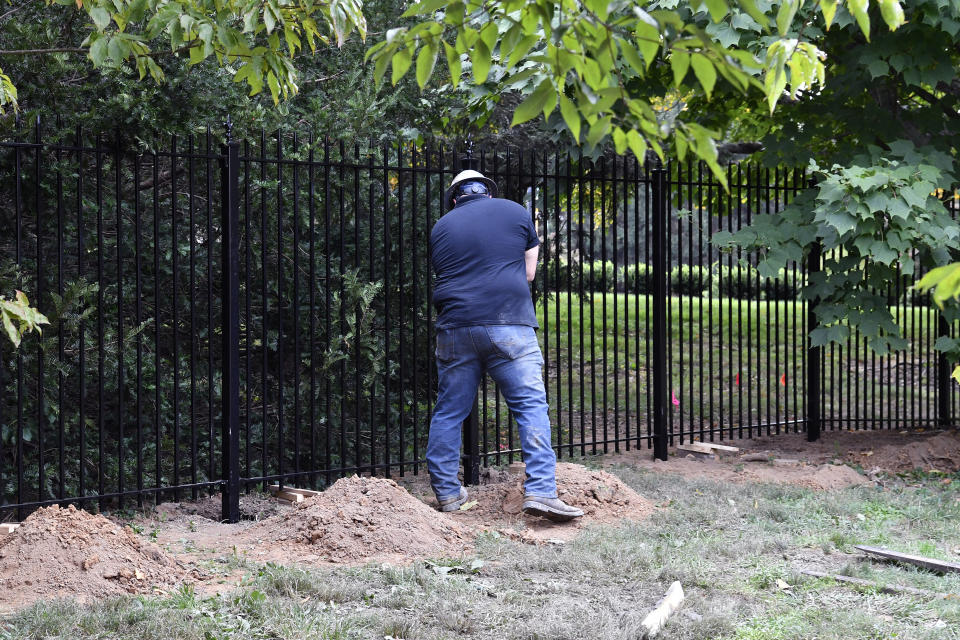 Workers with Stewart Construction install a security fence around the Governors' Mansion on the grounds of the Kentucky State Capitol in Frankfort, Ky., Friday, Oct. 9, 2020. Security is being increased following a plot to kidnap the Governor of Michigan, and Andy Beshear, a Democrat, was hanged in effigy from a tree during a May protest against his COVID-19 restrictions on the state Capitol grounds in Frankfort. (AP Photo/Timothy D. Easley)