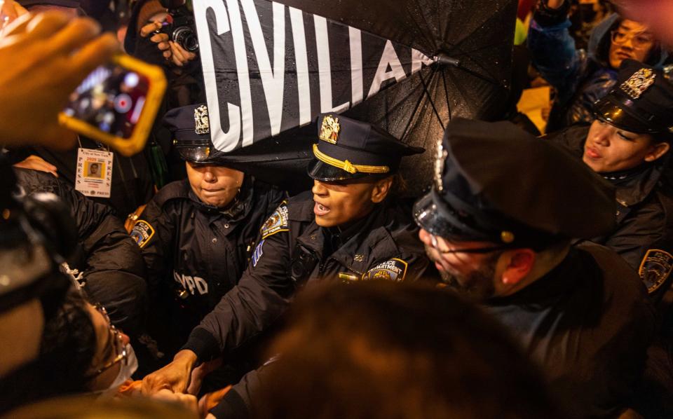 Pro-Palestinian demonstrators clash with NYPD officers trying to prevent protestors from standing on a ledge near Radio City Music Hall during President Joe Biden's fundraiser on March 28, 2024 in New York City. Biden will be joined by former presidents Bill Clinton and Barack Obama at the fundraiser.