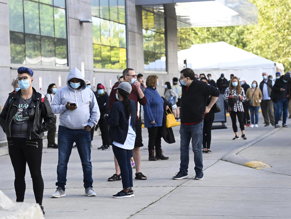 Hundreds of people wait in line for hours at a COVID-19 assessment centre at Women's College Hospital during the coronavirus pandemic in Toronto, Wednesday, Sept. 23, 2020. (Nathan Denette/The Canadian Press via AP)