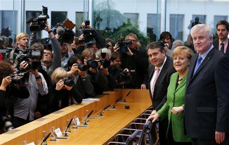 Party leaders German Chancellor Angela Merkel (C) of the Christian Democratic Union (CDU), Horst Seehofer (R) of the Christian Social Union (CSU) and Sigmar Gabriel of the Social Democratic Party (SPD) arrive for a news conference after signing a preliminary agreement, which has still to be approved by the members of the SPD, in the Bundespressekonferenz in Berlin, November 27, 2013. REUTERS/Pawel Kopczynski