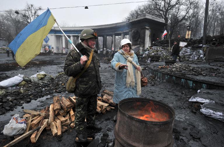 Protesters warm themselves in font of a fire at barricades on the Grushevsky street in Kiev on February 9, 2014